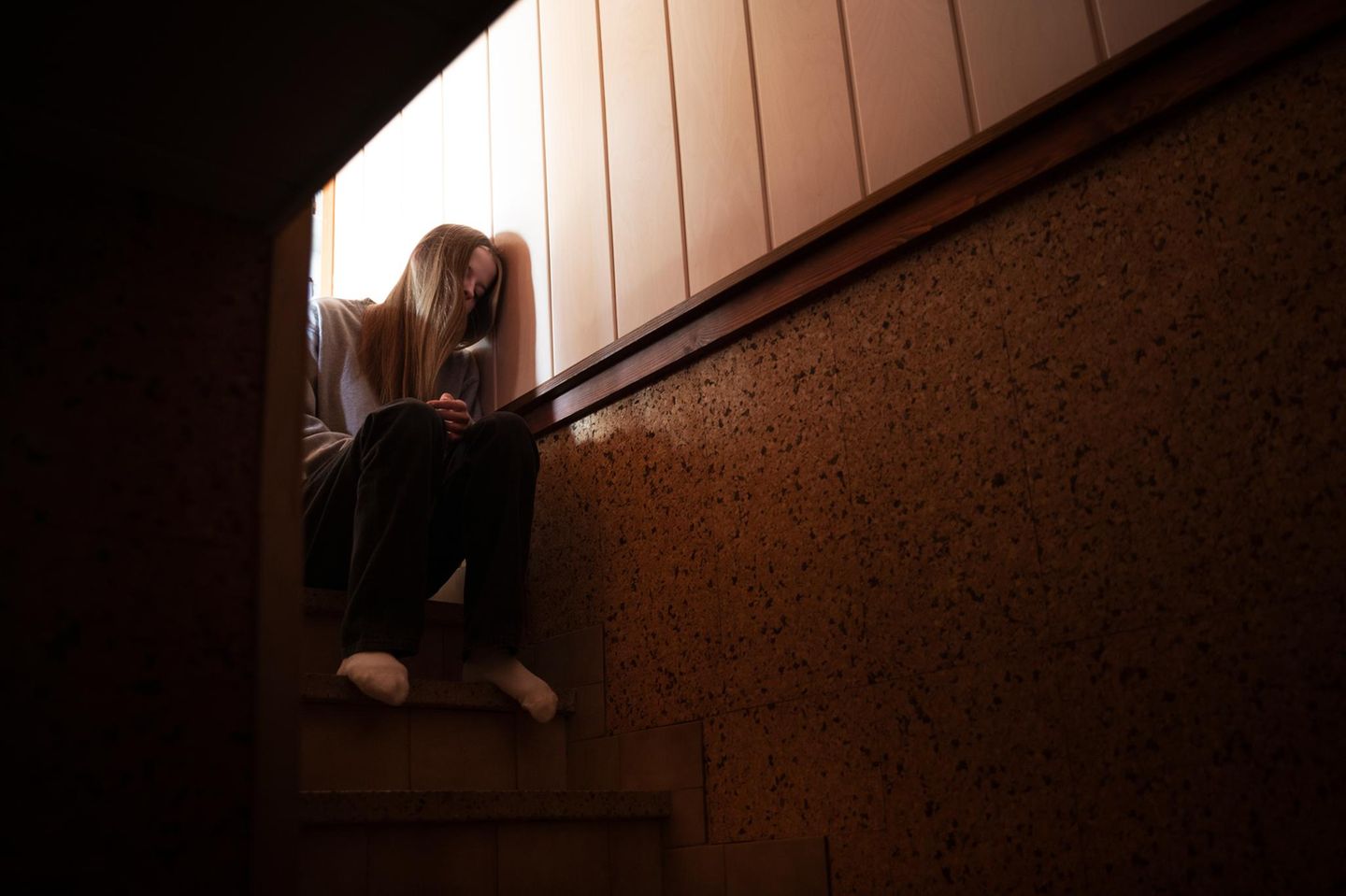 Mädchen sitzt traurig auf einer Treppe