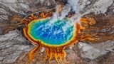 Dampf steigt aus dem sehr farbenfrohenden Geysir im Yellowstone auf