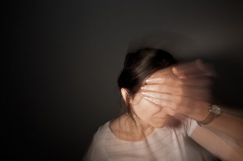 Frau greift sich an den Kopf