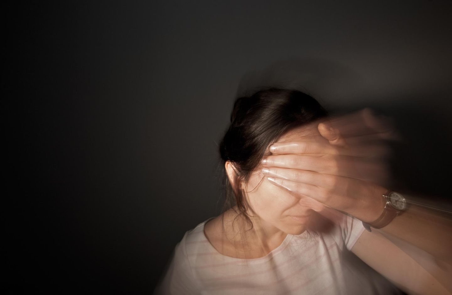 Frau greift sich an den Kopf