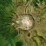 Mount Tambora: Grüne Landschaft auf der sich ein kreisrunder Krater abzeichnet