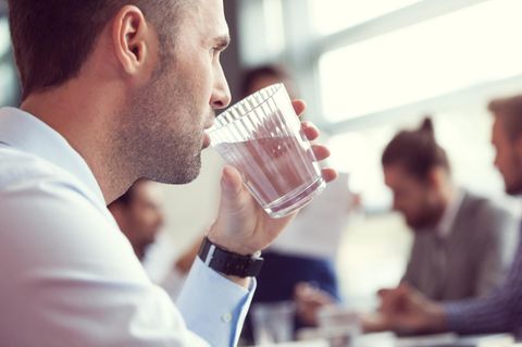 Geschäftsmann trinkt ein Glas Wasser