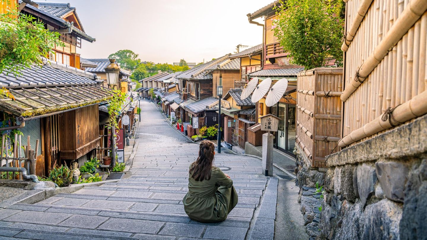 Faszinierende Geisha-Kultur: das Traditionsviertel Gion Person auf Straße in Gion, links und rechts Häuser