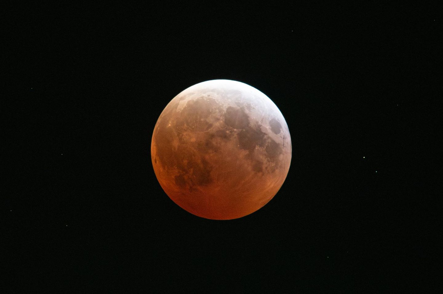 Bei einer totalen Mondfinsternis tauchen die Sonnenstrahlen im Wechselspiel mit der Erdatmosphäre den Mond in rotes Licht