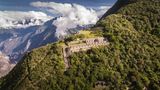 Ruine auf einem bewaldeten Berg auf Höhe der Wolken