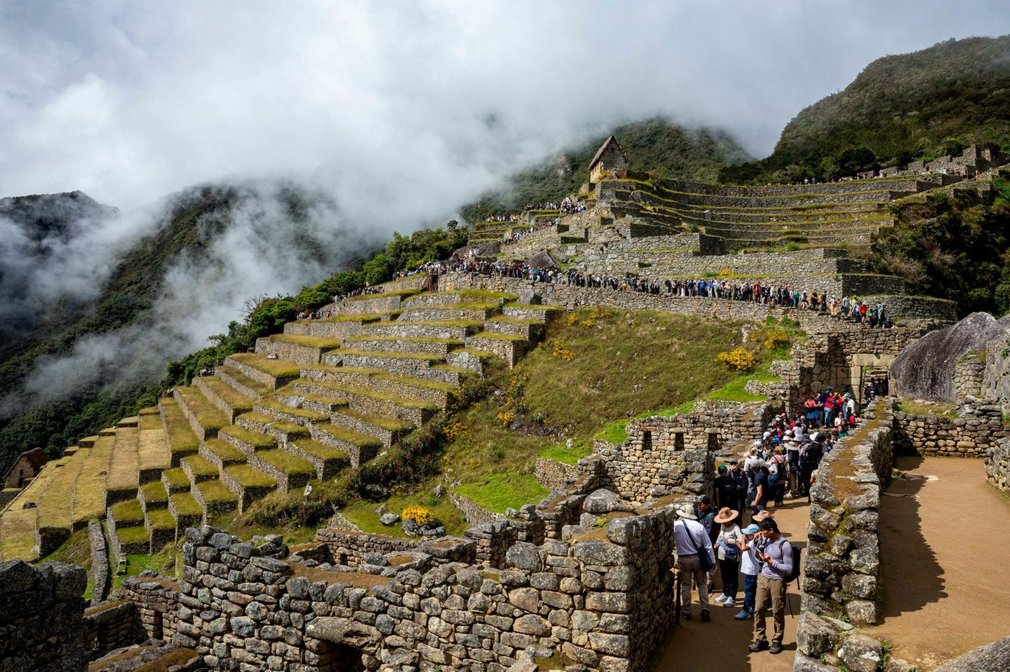 Machu Picchu: Ruinen trotzen dem Touristensturm Schlange an Menschen auf den Wegen einer Ruine am Berg zu Machu Picchu