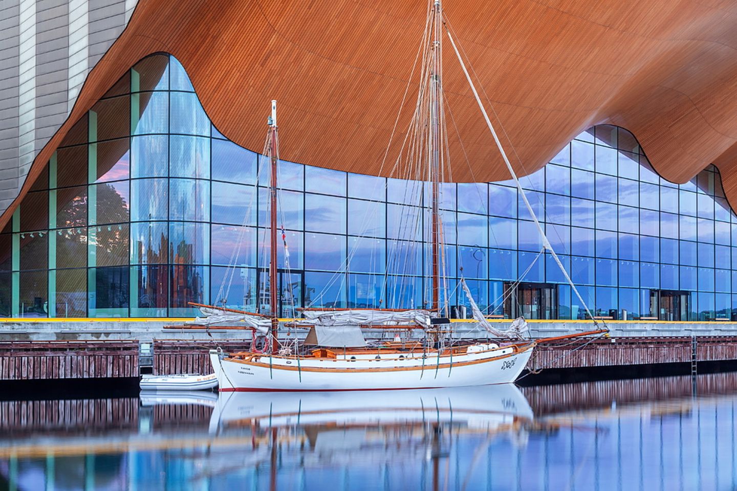 Hersehen und hinhören: Theater- und Konzerthaus Kilden  Glasfassade und Eichenholzdach des Kilden Theater- und Konzerthauses, davor Schiff im Wasser
