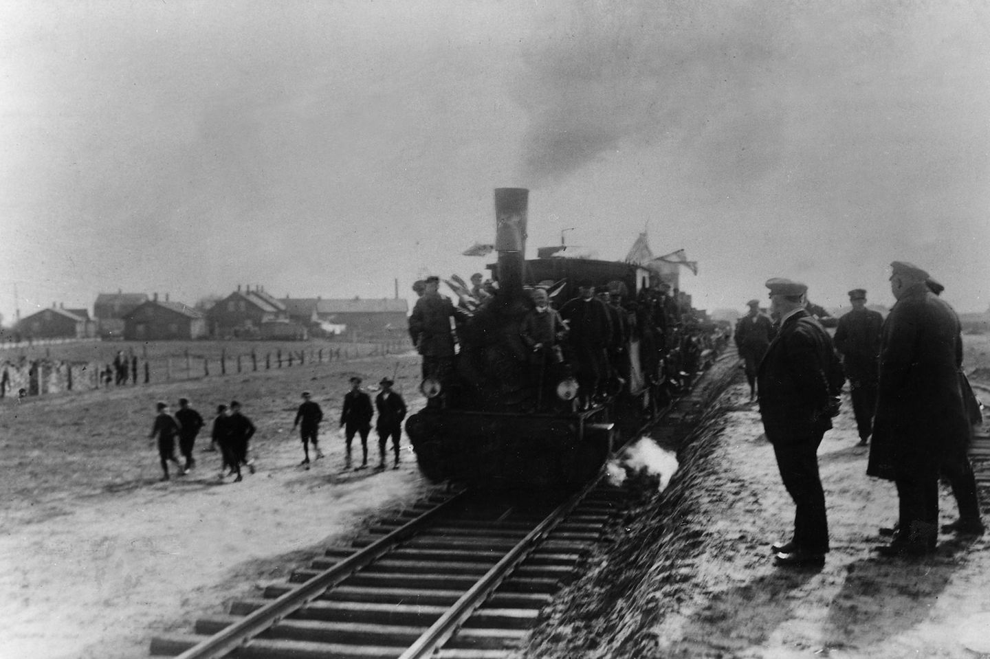 Menschen beobachten, wie Zug über Gleise fährt