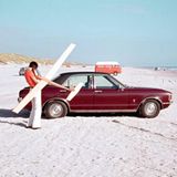 Person hält auf Strand Segelflugzeug in den Händen