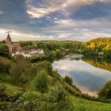 Elevated view of the Ulmener Maar and its shores, with the village of Ulmen at sunset, a volcanic lake and crater part of the Eifel National Park (Vulkaneifel) on the German volcanic route, an UNESCO Geopark, Daun - Rhineland-Palatinate - Germany.