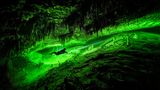 Taucher in Karsthöhle mit Tropfsteinen
