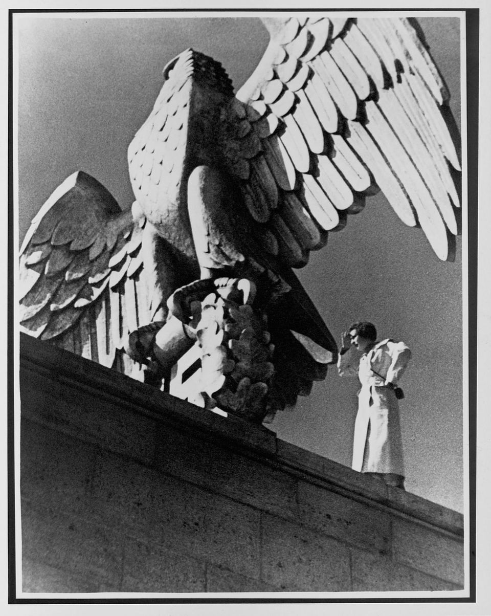 Leni Riefenstahl steht neben einem steinernen Reichsadler