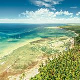 Ein endlos erscheinender schneeweißer Sandstrand, gesäumt von schattenspendenden Palmen