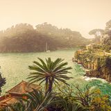 Pastellfarbene Häuser säumen die Steilküste einer mediterranen Bucht