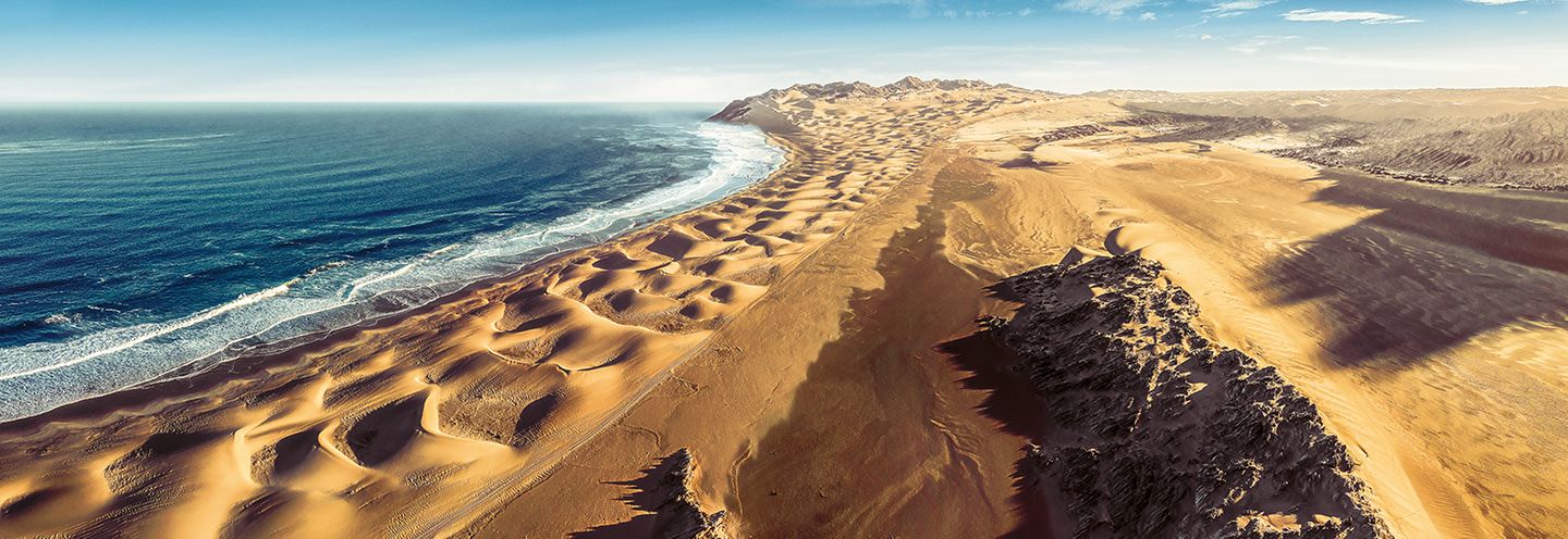 Endlos wirkende Sanddünen treffen auf den Atlantik