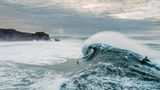 Surfer vor Riesenwelle
