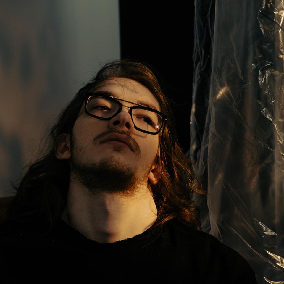 Mann im Halbdunkel schaut melanchlisch nach oben