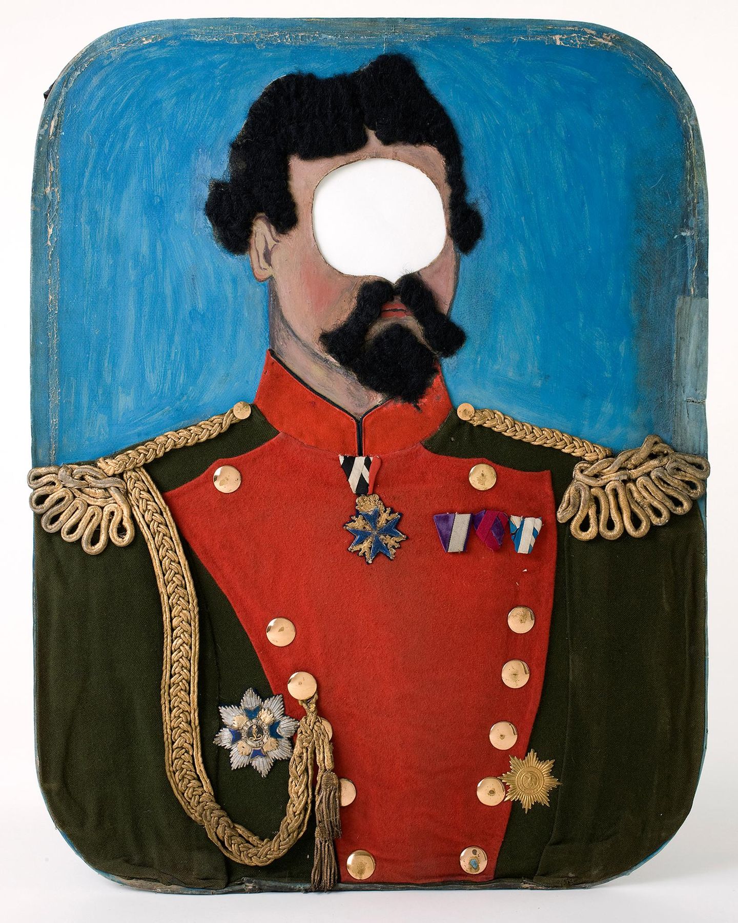 Ein bemaltes Schild, auf dem König Ludwig II abgebildet ist, mit einem Loch an Stelle seiner Augen