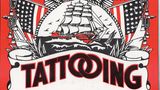 Schild mit der Aufschrift "Tattooing" und US-Flaggen
