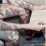 Mann mit tätowierten Beinen liest ein Buch