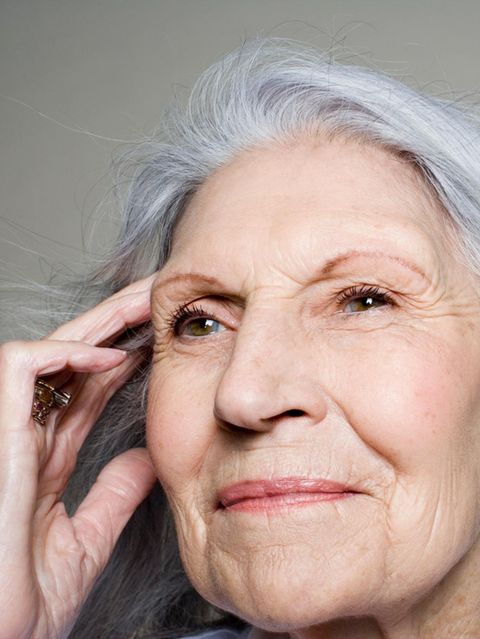 Frau fasst sich an die Schläfen und schaut in die Ferne