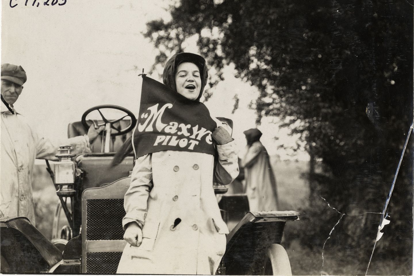 Beifahrerin Hermine Jahns schreit vor Freude vor dem Maxwell-Tourenwagen, August 1909