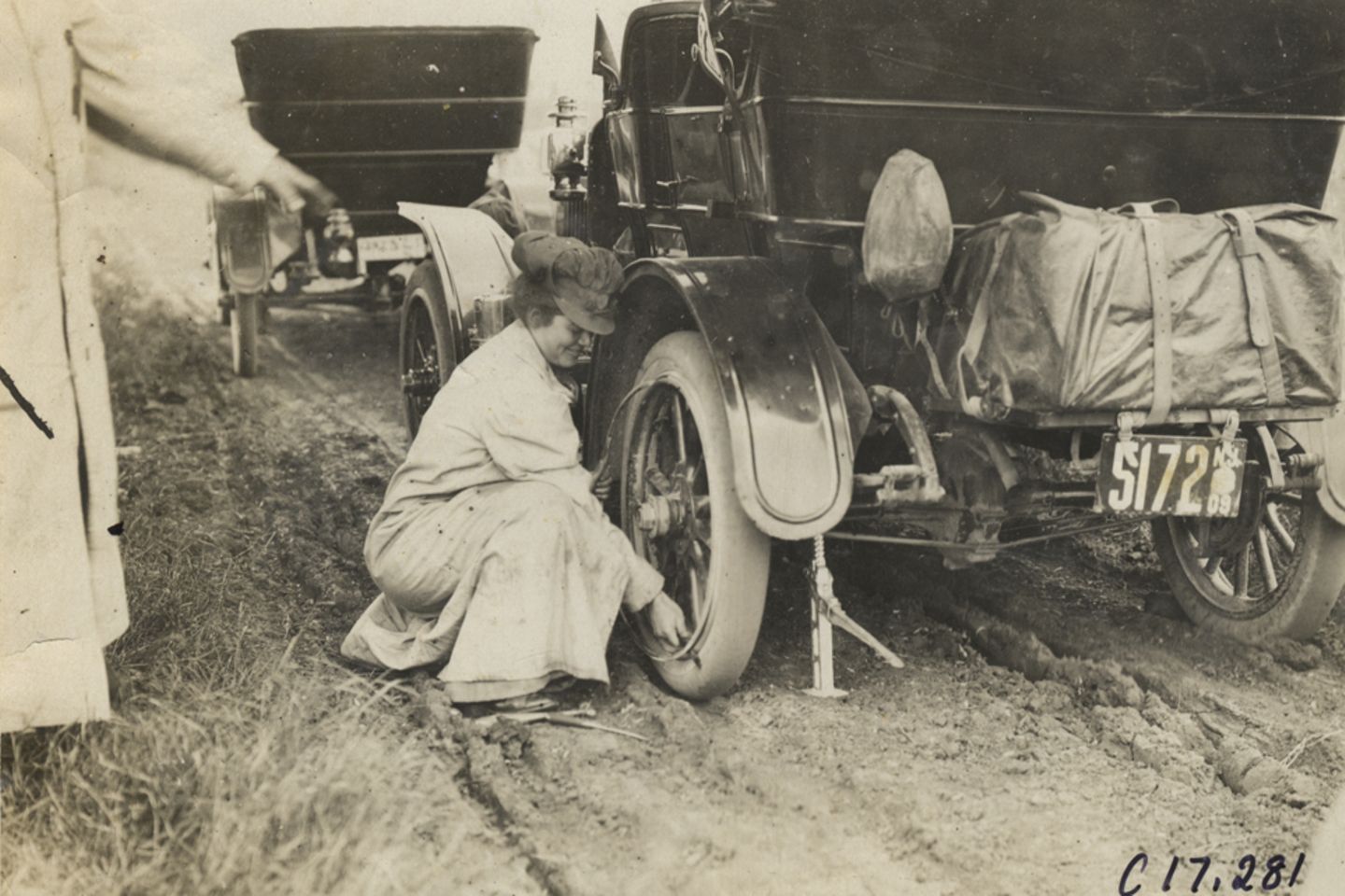 Alice Ramsey wechselt an einem Maxwell-Tourenwagen einen Reifen