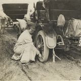 Alice Ramsey wechselt an einem Maxwell-Tourenwagen einen Reifen