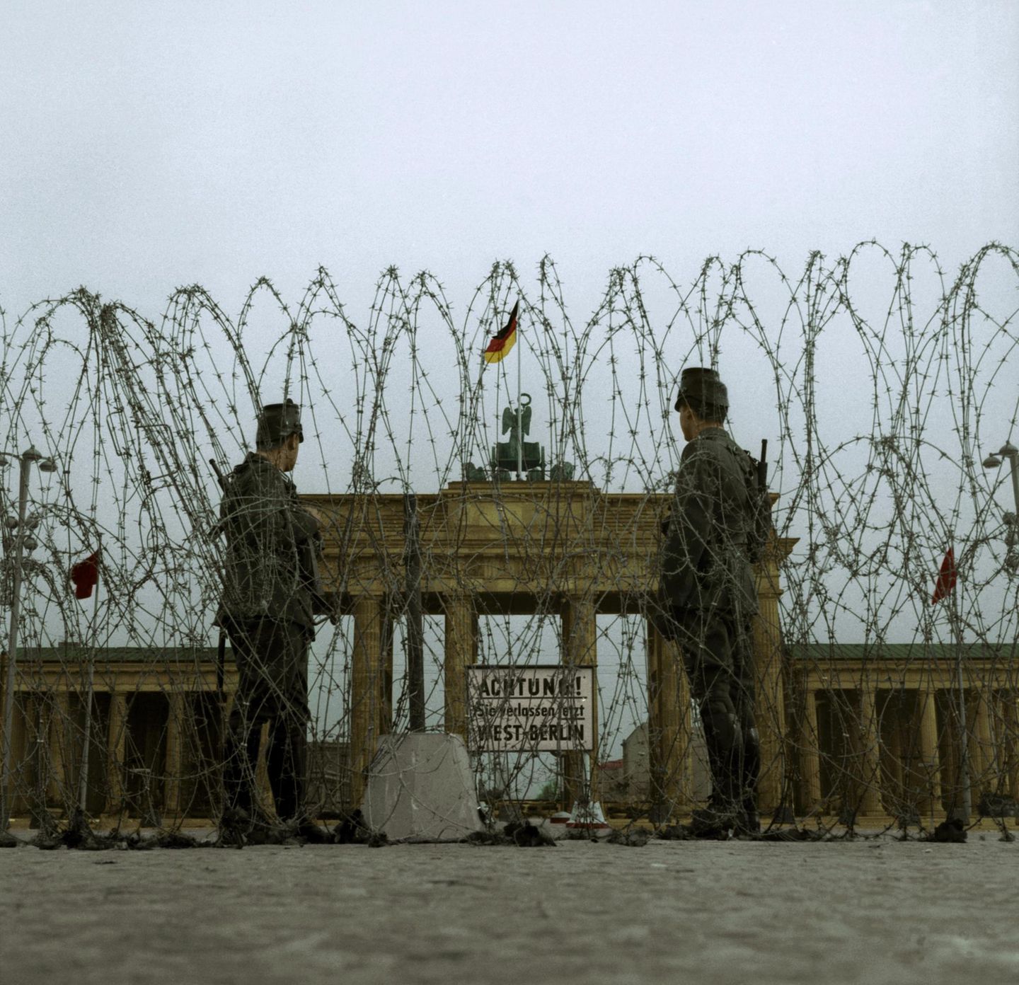 Westberliner Polizisten vor Brandenburger Tor und Stacheldraht