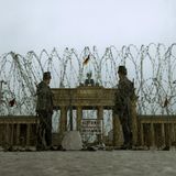 Westberliner Polizisten vor Brandenburger Tor und Stacheldraht