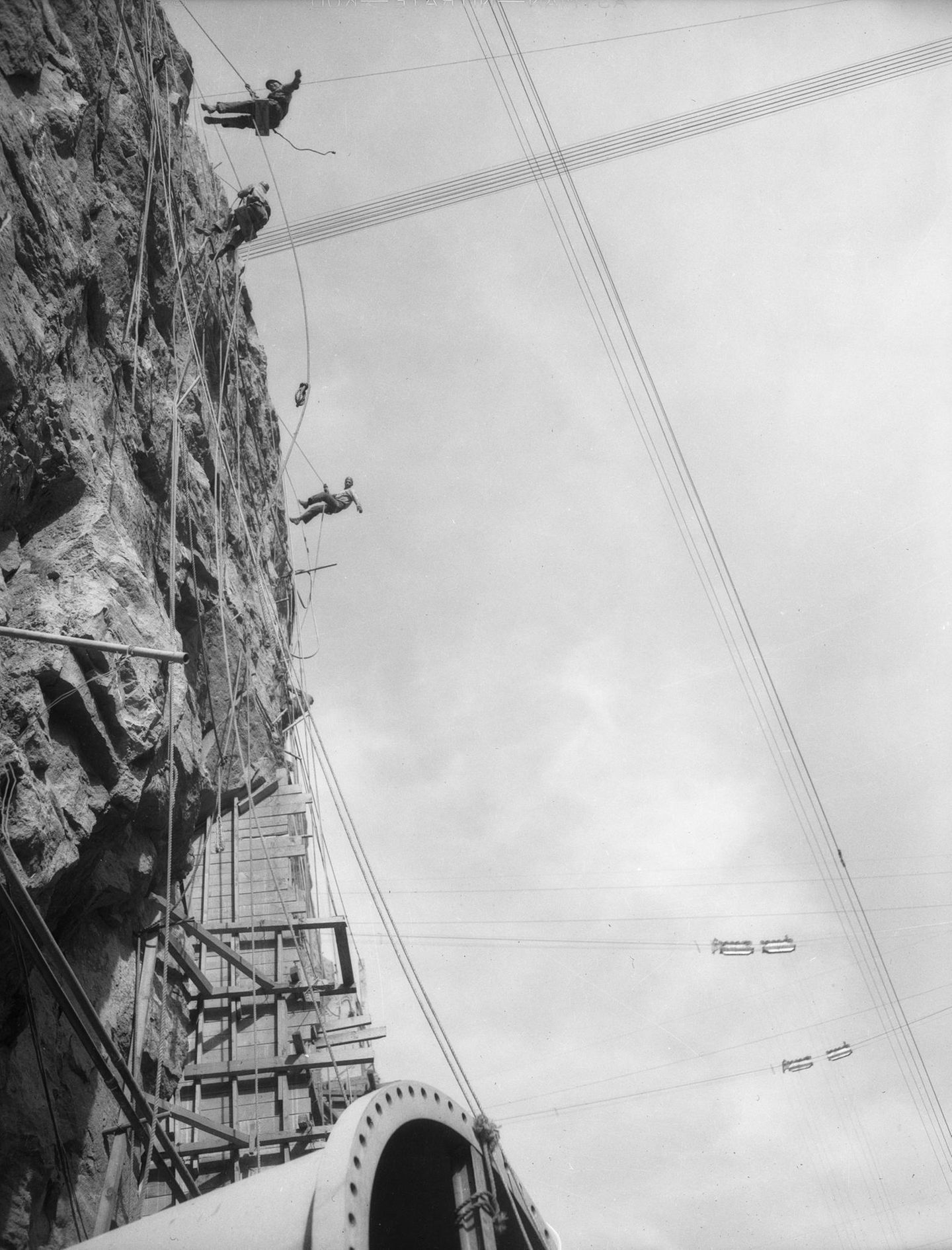 Menschen klettern an der Baustelle des Damms