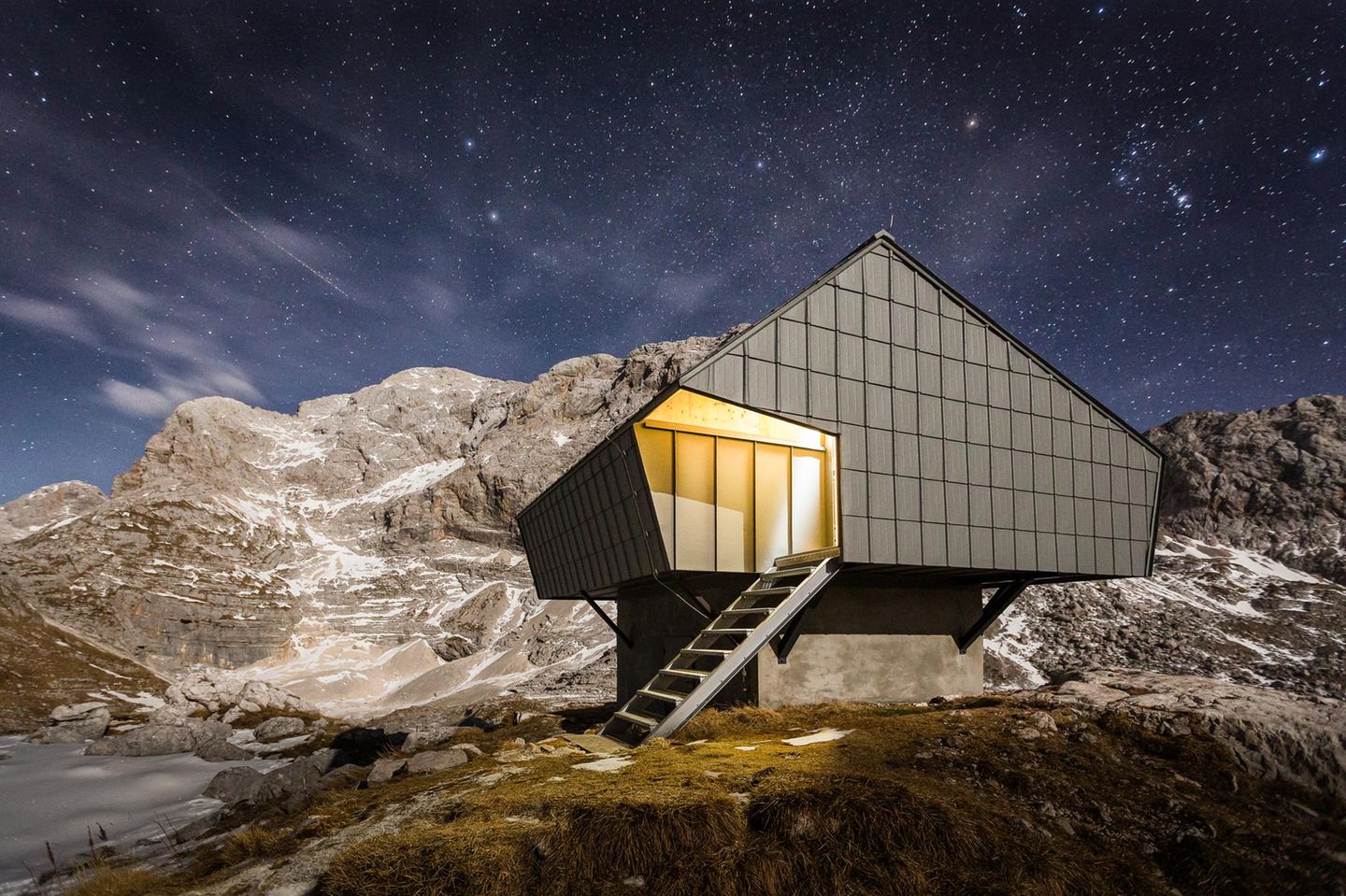 Bivak na Prehodavcih im Triglav-Nationalpark, Slowenien Diese außergewöhnliche Schutzhütte wurde auf etwa 2.000 Metern Höhe im Herzen der Julischen Alpen in Slowenien gebaut. Nahe wichtiger Bergsteigerrouten gelegen, dient sie als unverzichtbarer Rückzugsort für Bergsteiger, Wanderer und Skitourengeher, die den Triglav-Nationalpark abseits der Hauptsaison erkunden. Trotz seiner einfachen Ausstattung überzeugt das Biwak durch ein durchdachtes, asymmetrisches Design, das ganzjährig den starken Alpenwinden standhält und verhindert, dass sich im Winter Schnee auf dem Dach ansammelt.