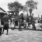 Einheimische Zwangsarbeiter vor Zug in Deutsch-Ostafrika