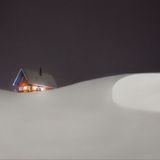 Eine Hütte auf einem schneeverschneiten Hügel