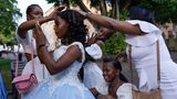 Freunde und Familie umsorgen eine 15-Jährige, die ihre "Quinceañera" feiert – ein traditionelles Fest zum 15. Geburtstag eines Mädchens in Lateinamerika. Es symbolisiert den Übergang von der Kindheit zum Erwachsenwerden und stellt die offizielle Einführung der jungen Frau in die Gesellschaft dar. Die Aufnahme entstand, als sich die junge Frau auf ihre Fotosession auf der Plaza Colón im Stadtteil Zona Colonial in Santo Domingo vorbereitete.