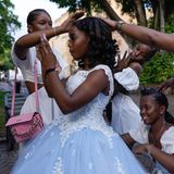 Freunde und Familie umsorgen eine 15-Jährige, die ihre "Quinceañera" feiert – ein traditionelles Fest zum 15. Geburtstag eines Mädchens in Lateinamerika. Es symbolisiert den Übergang von der Kindheit zum Erwachsenwerden und stellt die offizielle Einführung der jungen Frau in die Gesellschaft dar. Die Aufnahme entstand, als sich die junge Frau auf ihre Fotosession auf der Plaza Colón im Stadtteil Zona Colonial in Santo Domingo vorbereitete.