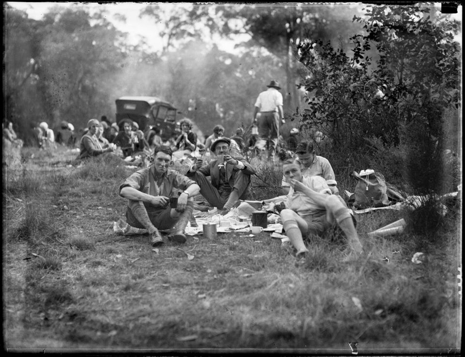 Menschen sitzen im Gras und picknicken Menschen sitzen im Gras und picknicken