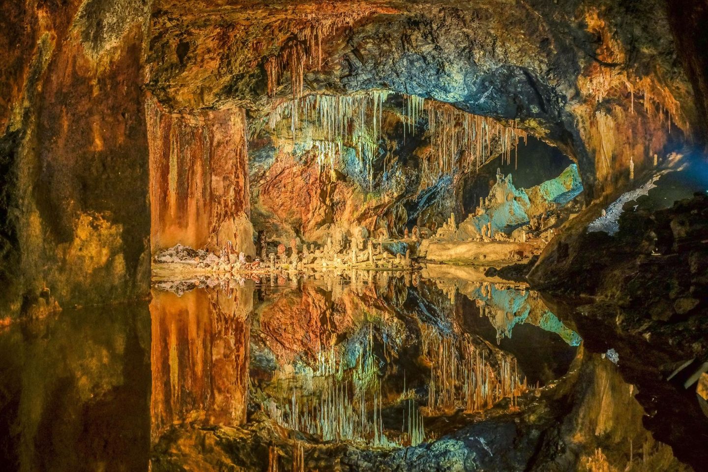 Saafelder Feengrotten: Verwunschene Höhlenwelt Die Tropfsteinhöhle Saafelder Feengrotten, welche bunt beleuchtet wird in orange und türkis