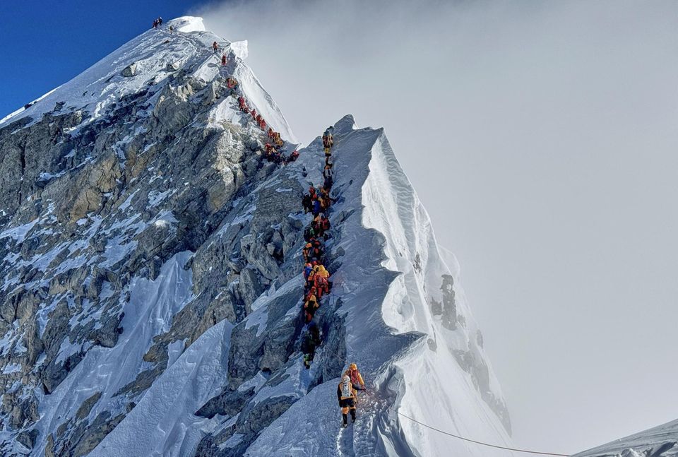 Eine lange Schlange von Bergsteigern auf dem Gipfelgrat zum Mount Everest