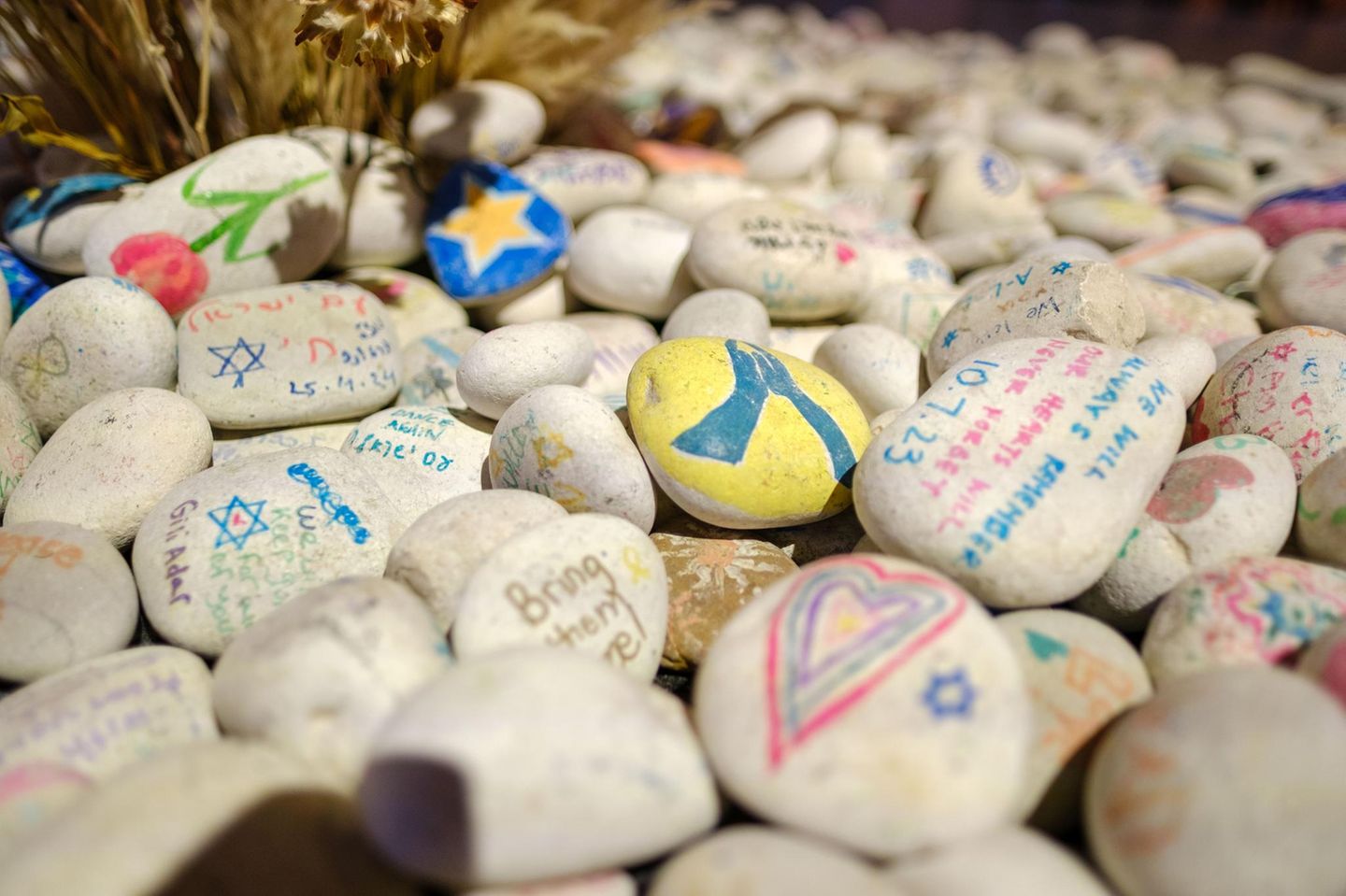 Bunt bemalte Steine, darauf David-Sterne, Wünsche, Herzen, Hoffnungen