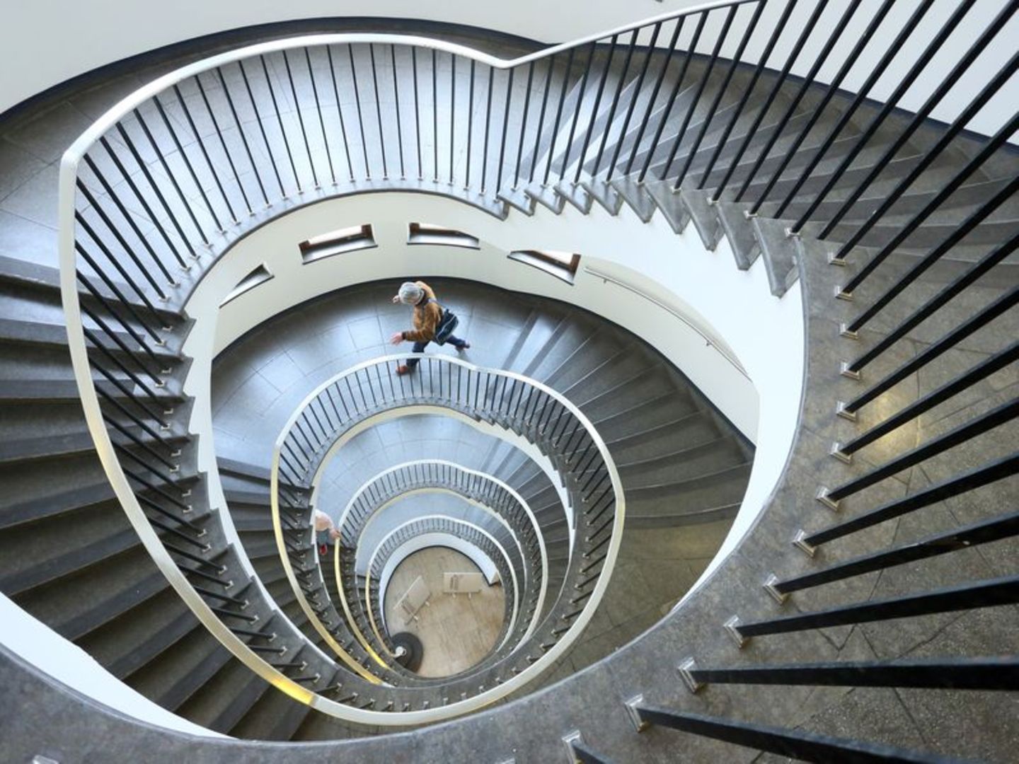Person läuft durch rundes Treppenhaus