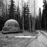 Ein Waldweg in Finnland, an dessen Straßenrand ein kugelförmiges Observatorium steht