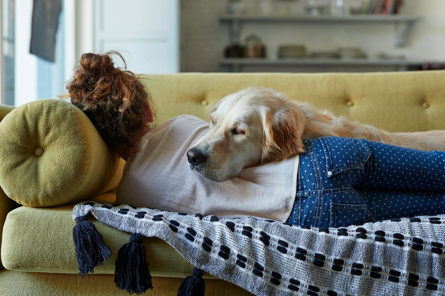 Frau schläft mit Hund auf dem Sofa
