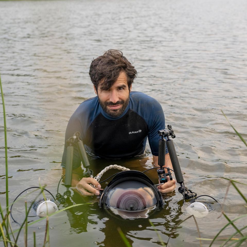 Fotograf Jon A. Juárez im Fluss mit Neoprenanzug bei der Arbeit