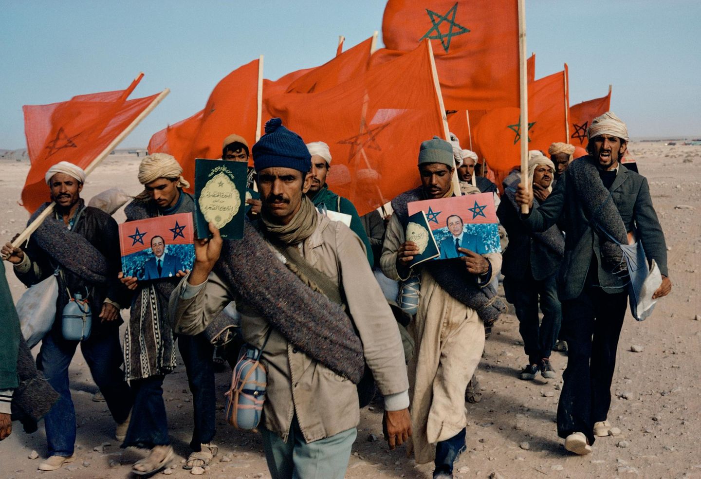 Menschen tragen marokkanische Flagge und den Koran