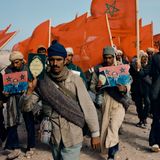 Menschen tragen marokkanische Flagge und den Koran