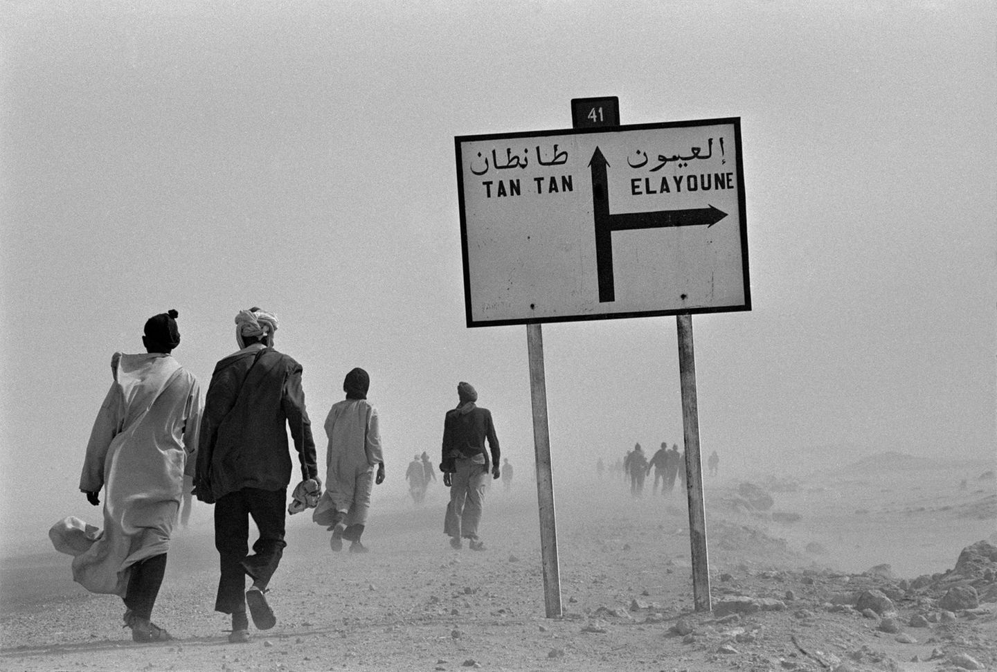 Menschen laufen über staubige Piste