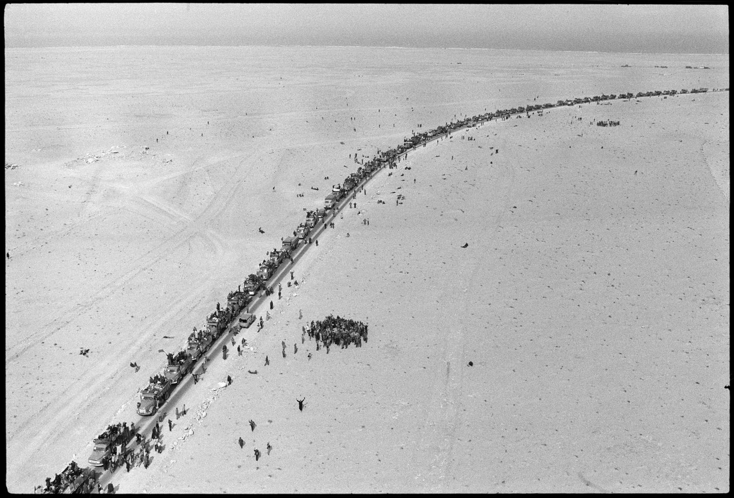 Kolonne von Autos auf einer Straße in einem Wüstengebiet