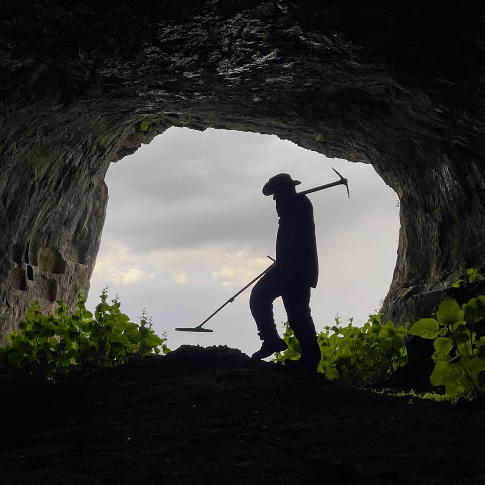 Schatzsucher mit Metalldetektor sucht in der Höhle