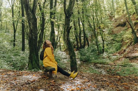 Frau sitzt im Wald